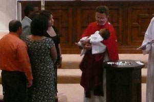 Father Norm baptizes young member